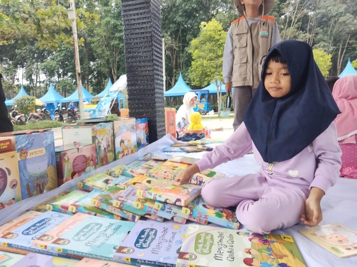 Pegiat literasi di Asahan saat menggelar buku-buku yang bisa dibaca masyarakat secara gratis di hutan kota. (Perdana Ramadhan/detikSumut)