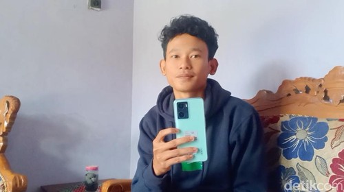 Muhammad Agung Hidayatullah tersangka kasus hacker Bjorka menunjukkan ponsel yang diberi polisi