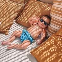 Tak hanya bermain pasir dan berenang, baby Izz juga tampak berjemur sambil menikmati suasana pantai di Yunani. Mengenakan kaca mata hitam, celana biru bermotif dan kemeja oranye yang tak dikancing, penampilan baby Izz sukses bikin gemas. Foto: Instagram/@indpriw