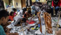 Sejumlah anak menyelesaikan pembuatan wayang dari sampah plastik.