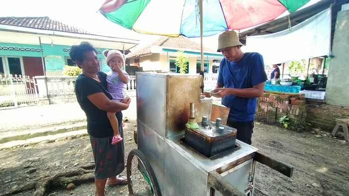 Suciono saat menjual kue putu di Kota Negara, Jembrana
