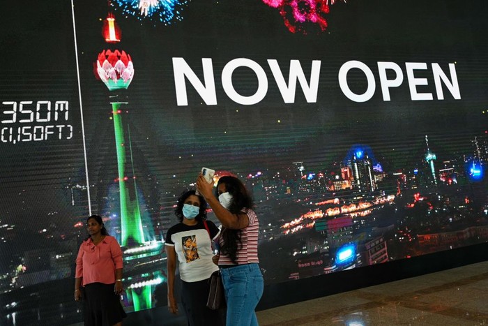 1243251285 Visitors take pictures in front of the Sri Lankan 'white elephant' Chinese-built Lotus Tower after it was opened for public in Colombo on September 15, 2022. (Photo by Ishara S. KODIKARA / AFP) (Photo by ISHARA S. KODIKARA/AFP via Getty Images)