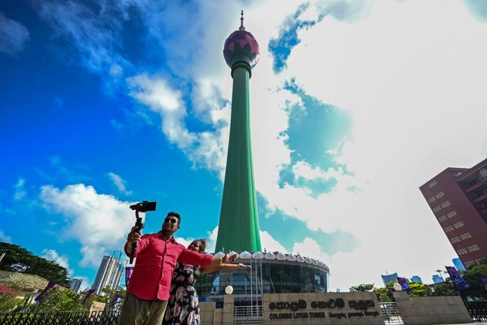 1243251285 Visitors take pictures in front of the Sri Lankan 'white elephant' Chinese-built Lotus Tower after it was opened for public in Colombo on September 15, 2022. (Photo by Ishara S. KODIKARA / AFP) (Photo by ISHARA S. KODIKARA/AFP via Getty Images)