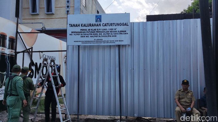 Anggota Linmas dari Kalurahan Caturtunggal Sleman mulai menutup lokasi kafe itu dengan memasang galvalum, Senin (19/9/2022).