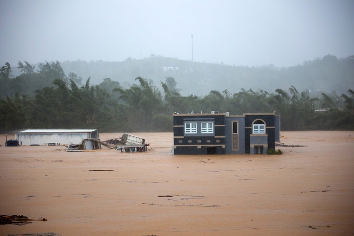 People clean debris from a road after a mudslide caused by Hurricane Fiona in Cayey, Puerto Rico, Sunday, Sept. 18, 2022. (AP Photo/Stephanie Rojas)