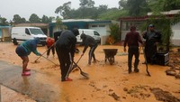 Warga berusaha membersihkan lumpur sisa banjir di Cayey, Puerto Rico.