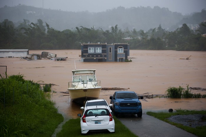Badai Fiona Sebabkan Banjir dan Longsor di Puerto Rico People clean debris from a road after a mudslide caused by Hurricane Fiona in Cayey, Puerto Rico, Sunday, Sept. 18, 2022. (AP Photo/Stephanie Rojas)