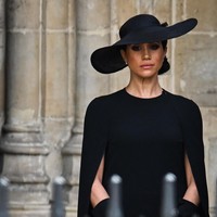 Meghan Markle juga menonjolkan aura elegannya dengan gaun hitam bersiluet lurus yang dilengkapi cape dan sarung tangan senada. Sebuah topi juga dipakainya dengan ukuran yang lebih besar dari milik Kate. (Foto: AFP via Getty Images/OLI SCARFF)