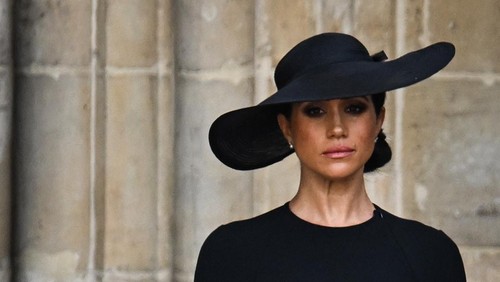 Meghan, Duchess of Sussex looks at the coffin of Queen Elizabeth II, draped in a Royal Standard and adorned with the Imperial State Crown and the Sovereigns orb and sceptre, as she leaves Westminster Abbey in London on September 19, 2022, after the State Funeral Service for Britains Queen Elizabeth II. (Photo by Oli SCARFF / AFP) (Photo by OLI SCARFF/AFP via Getty Images)