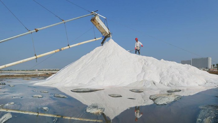 Pemandangan udara dari seorang pekerja yang memanen garam di ladang garam pada 18 September 2022 di Lianyungang, Provinsi Jiangsu, Tiongkok
