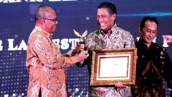 Dominasi Pasar KPR Terbesar di Indonesia Direktur Consumer PT Bank Tabungan Negara (Persero) Tbk. Hirwandi Gafar (tengah) tersenyum saat menerima penghargaan