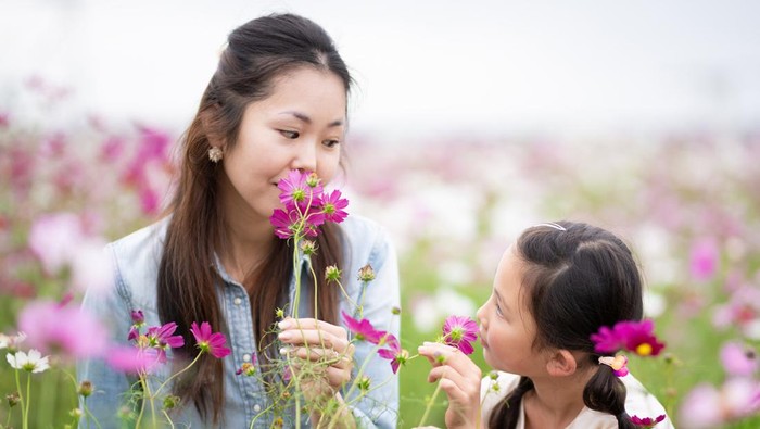 Mother and daughter playing in a flower field