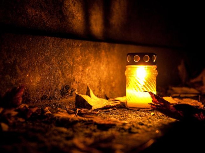 Candle burning with nice yellow colour with leaves all around.