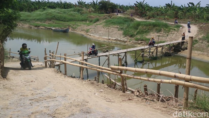 Jembatan kayu di Sungai Wulan penghubung Desa Setrokalangan Kecamatan Kaliwungu Kabupaten Kudus dengan Desa Kedungwaru Kecamatan Karanganyar Kabupaten Demak, Senin (19/9/2022).