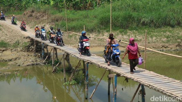 Jembatan kayu di Sungai Wulan penghubung Desa Setrokalangan Kecamatan Kaliwungu Kabupaten Kudus dengan Desa Kedungwaru Kecamatan Karanganyar Kabupaten Demak, Senin (19/9/2022).