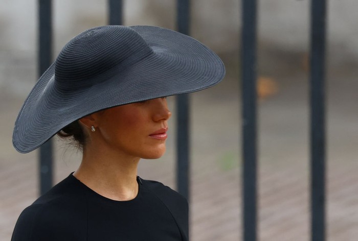 Meghan, Duchess of Sussex looks at the coffin of Queen Elizabeth II, draped in a Royal Standard and adorned with the Imperial State Crown and the Sovereigns orb and sceptre, as she leaves Westminster Abbey in London on September 19, 2022, after the State Funeral Service for Britains Queen Elizabeth II. (Photo by Oli SCARFF / AFP) (Photo by OLI SCARFF/AFP via Getty Images)