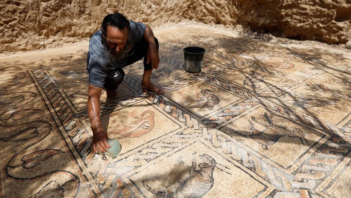 Petani Gaza Temukan Lantai Mosaik Era Bizantium Palestinian farmer Salman al-Nabahin cleans a mosaic floor he discovered at his farm and which dates back to the Byzantine era, according to officials, in the central Gaza Strip September 18, 2022. REUTERS/Ibraheem Abu Mustafa