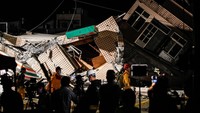 Tim penyelamat dengan peralatan berjalan melewati puing-puing bangunan tempat tinggal yang runtuh setelah gempa berkekuatan 6,8 melanda Taiwan, di Yuli, Hualien, Taiwan, Minggu, (18/9/2022). Ceng Shou Yi/NurPhoto/Getty Images