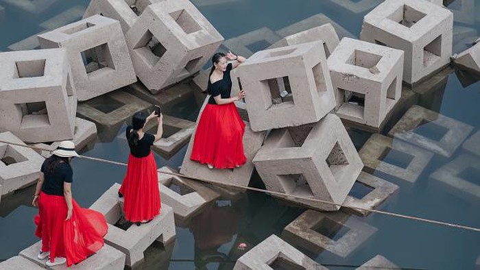 Punya Bentuk Estetik, Pemecah Gelombang di China Jadi Spot Foto-foto CHONGQING, CHINA - SEPTEMBER 17: Women pose for photos on ecological revetment bricks which are exposed along the Yangtze River on September 17, 2022 in Chongqing, China. The water level of Yangtze River has dropped due to sustained high temperatures and little rain. (Photo by Li Hongbo/VCG via Getty Images)