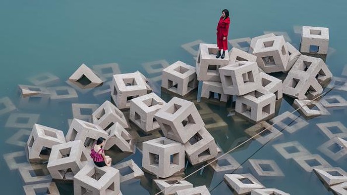 CHONGQING, CHINA - SEPTEMBER 17: Women pose for photos on ecological revetment bricks which are exposed along the Yangtze River on September 17, 2022 in Chongqing, China. The water level of Yangtze River has dropped due to sustained high temperatures and little rain. (Photo by Li Hongbo/VCG via Getty Images)