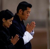 Raja Jigme Khesar Namgyel Wangchuck dan Ratu Jetsun Pema terlihat berdoa di depan peti jenazah Ratu Elizabeth II pada Senin (19/9/2022) di Westminster Hall, London. Keduanya berdoa dengan khusyuk sambil menutup kedua mata.  Foto: SARAH MEYSSONNIER, John Sibley-WPA Pool/Getty Images