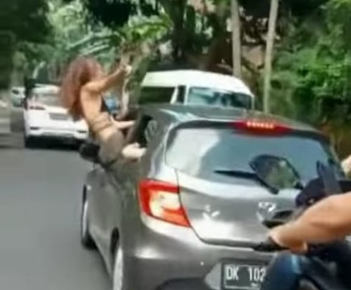 Tangkapan layar video oknum WNA yang keluar kaca mobil sambil menari hingga akhirnya viral