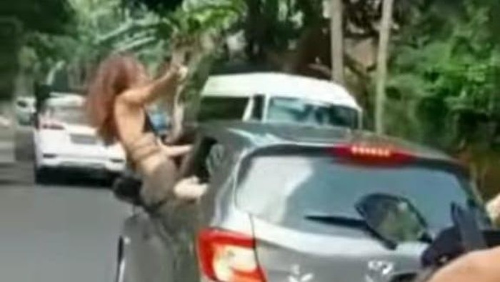 Tangkapan layar video oknum WNA yang keluar kaca mobil sambil menari hingga akhirnya viral