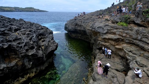 Foto udara wisatawan mengunjungi Broken Beach, Nusa Penida, Klungkung, Bali, Sabtu (17/9/2022). Kunjungan wisatawan ke Nusa Penida yang merupakan salah satu destinasi pariwisata unggulan di Bali itu saat ini terus meningkat dengan rata-rata kunjungan 2.000 hingga 3.000 orang wisatawan per hari. ANTARA FOTO/Fikri Yusuf/aww.