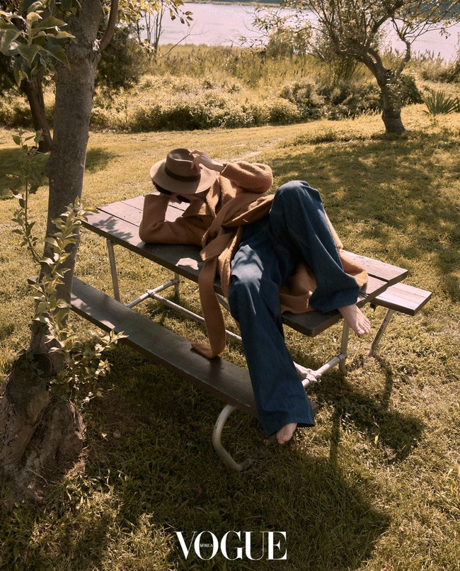 Pemilik akun Instagram @thv itu membuat penggemar histeris saat mengunggah fotonya telanjang dada yang diambil dari belakang dan mengekspos bahu bidangnya. Foto tersebut diambil di sela-sela pemotretan V BTS memakai coat panjang berwarna coklat Amiri dan celana rancangan Kimseoryong. Tanpa memakai alas kaki, V BTS menutup wajahnya dari paparan sinar matahari memakai topi fedora Ecua-Andino. Foto: dok. Vogue Korea