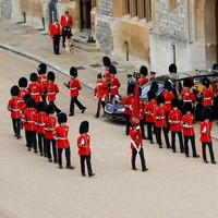 Dijaga dua orang staf berseragam merah, Muick dan Sandy menantikan kedatangan peti Ratu Elizabeth II di salah satu sudut Kastil Windsor. Mereka sabar menunggu dengan tenang sampai akhirnya mobil jenazah yang membawa peti Ratu lewat di depan mereka. (Foto: Peter Nicholls - WPA Pool/Getty Images)