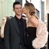 Ciuman hangat dari Behati Prinsloo untuk Adam Levine. Kala itu, sang vokalis Maroon 5 menerima pengakuan Hollywood Walk of Fame pada Februari 2017. (Foto: Getty Images)