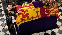 Usai mahkota hingga tongkat kerajaan diambil, Raja Charles III kemudian meletakkan bendera Ratu di atas peti jenazah Ratu Elizabeth.