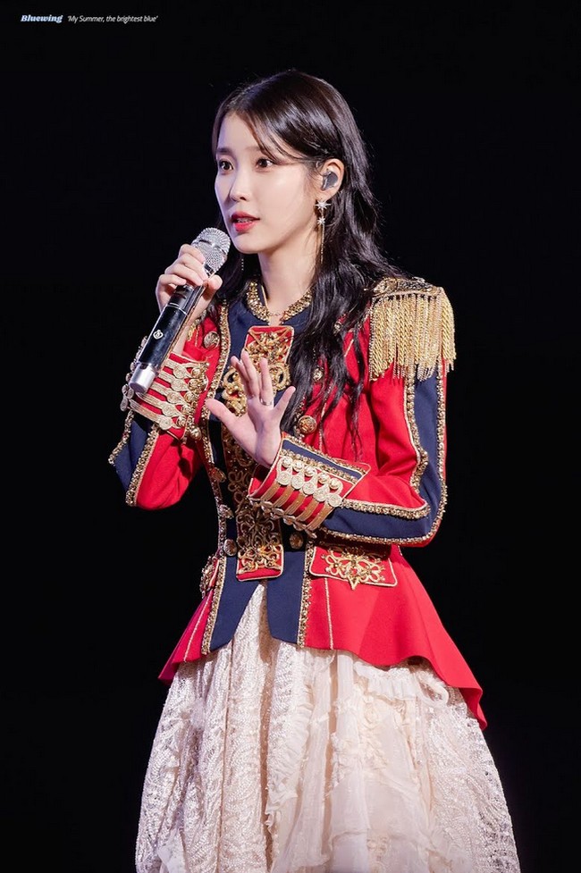Dalam penampilan lain, IU kembali menggabungkan gaun dengan kardigan. Kali ini ia melengkapi gaya feminin dengan tiara dan kalung yang membuatnya semakin bersinar. Foto: Dok. Fansite