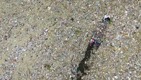 Penampakan dari udara orang-orang mengumpulkan limbah sisa plastik, kaca, dan bahan lainnya di Danau Suchitlan. Camilo Freedman/AFP/Getty Images