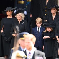 Inilah momen Meghan Markle menangis di sela-sela prosesi pemakaman Ratu Elizabeth II. Meghan tertangkap kamera menangis saat berdiri bersebelahan dengan permaisuri Camilla, Kate Middleton, Pangeran George dan Putri Charlotte. Foto: Dok. Getty Images, Wireimage