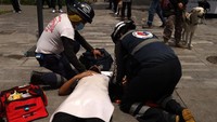 Seorang warga pingsan dan segera ditangani oleh tim medis. (Cristopher Rogel Blanquet/Getty Images)