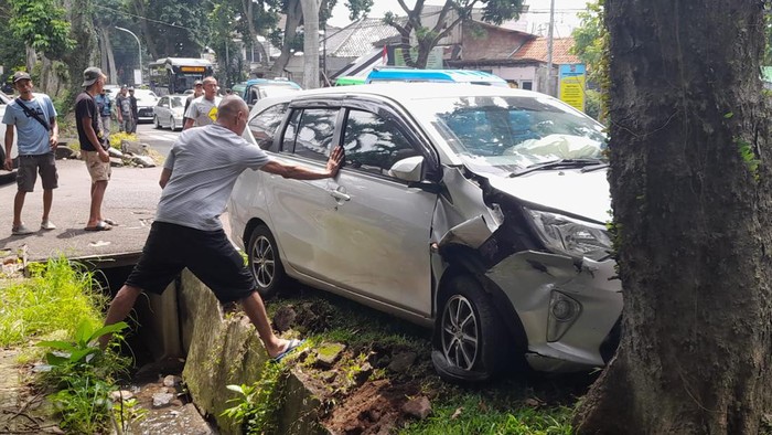 Mobil terperosok ke parit di Jl Ahmad Yani, Bogor, akhirnya dievakuasi, Selasa (20/9/2022) siang.