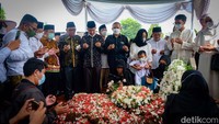Anak dan cucu-cucu almarhum berdoa di pusara.