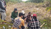 Rombongan duduk dan melakukan tabur bunga. Onee yang bermasker hitam dan memakai baju hitam motif bunga duduk di dekat TKP jasad suaminya ditemukan. Mereka berdoa di lokasi dan tampak Onee berlinang air mata. Foto: Afzal Nur Iman/detikJateng
