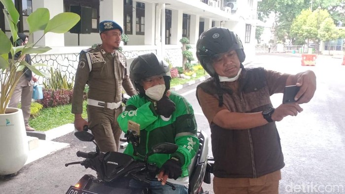 Pegawai Pemkot Makassar selfie bersama pengemudi ojol di Balai Kota Makassar.