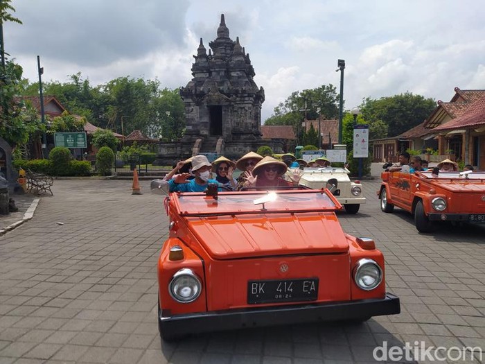 Pengunjung saat naik VW berfoto di depan Candi Pawon, Kabupaten Magelang.