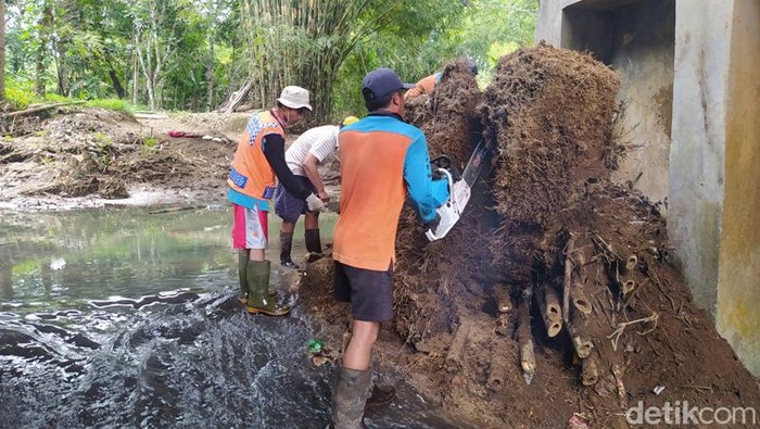 Para pekerja membersihkan kotoran sampah pohon bambu di Jembatan Tangsi, Kabupaten Magelang.