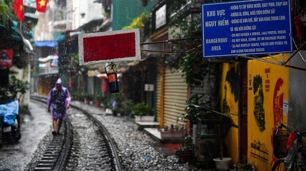 Seorang warga berjalan di jalur kereta api populer Hanoi yang telah ditutup di Hanoi, Vietnam, Jumat (16/9/2022) waktu setempat. (Nhac Nguyen/AFP/Getty Images)  