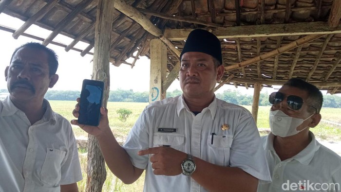 Kepala Desa (Kuwu) Bojong Kulon, Sudarso menunjukkan video aksi perundungan terhadap remaja berkebutuhan khusus di Cirebon.