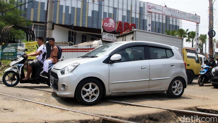 Perlintasan rel sebidang dekat Stasiun Cisauk, Tangerang, membuat lalu-lintas menjadi macet. Mereka melambatkan laju ketika melewati perlintasan rel.