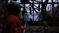 Seorang relawan pemadam kebakaran menyemprotkan air ke bangunan Kantor Badan Penelitian dan Pengembangan (Balitbang) Provinsi Kalimantan Barat yang habis terbakar di Pontianak, Kalbar, Selasa (20/9/2022).