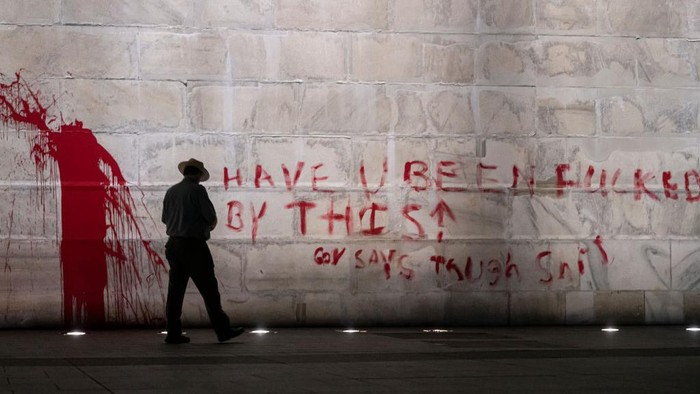 WASHINGTON, DC - SEPTEMBER 21: (EDITOR'S NOTE: Image contains profanity.) The U.S. Park Police guard the Washington Monument after a vandal wrote graffiti and threw red paint against the base of the structure on September 21, 2022 in Washington, DC. A spokesman for the U.S. Park Police said one man was in custody in connection to the incident. (Photo by Nathan Howard/Getty Images)