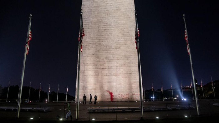 WASHINGTON, DC - SEPTEMBER 21: (EDITOR'S NOTE: Image contains profanity.) The U.S. Park Police guard the Washington Monument after a vandal wrote graffiti and threw red paint against the base of the structure on September 21, 2022 in Washington, DC. A spokesman for the U.S. Park Police said one man was in custody in connection to the incident. (Photo by Nathan Howard/Getty Images)