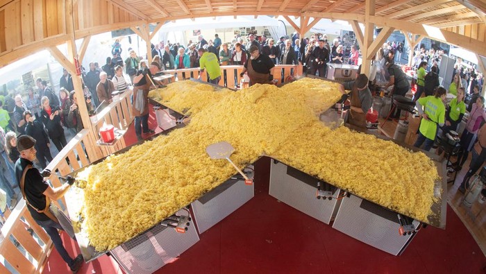 A chef fries grated potatoes in a 13.7 m2 pan to set a new world record for the largest roesti, a Swiss national dish, during the 