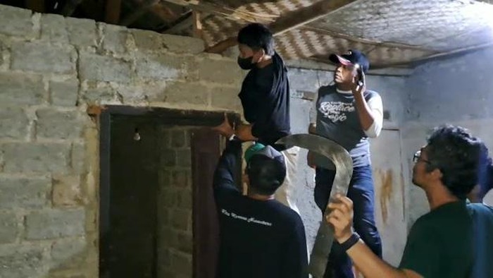 Polisi saat menggeladah rumah untuk mencari senjata tajam.